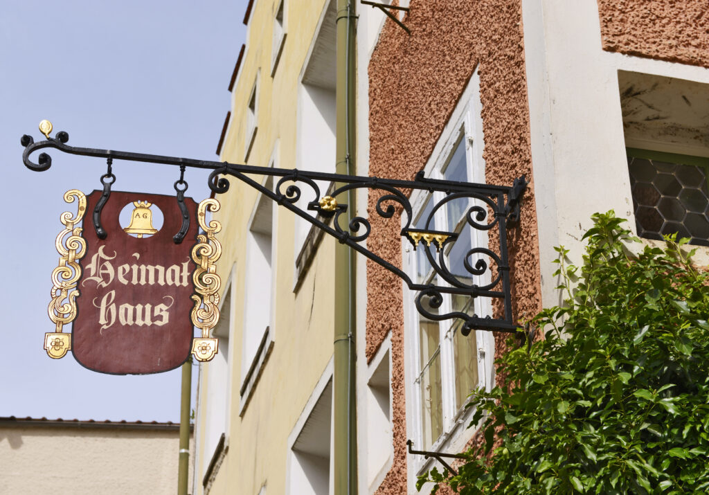 Heimathaus Braunau mit Glockengießerei Logo
